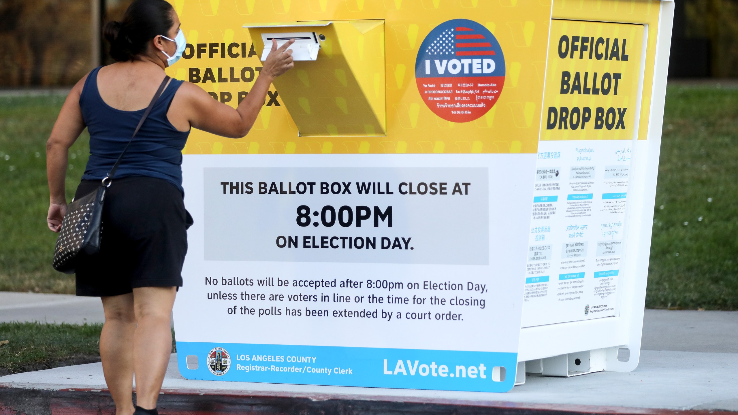 A voter places a ballot in an official mail-in ballot drop box outside of the L.A. County Registrar’s office in Norwalk on Oct. 14, 2020. (Mario Tama / Getty Images)