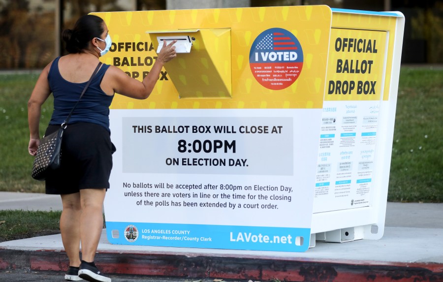 A voter places a ballot in an official mail-in ballot drop box outside of the L.A. County Registrar’s office in Norwalk on Oct. 14, 2020. (Mario Tama / Getty Images)