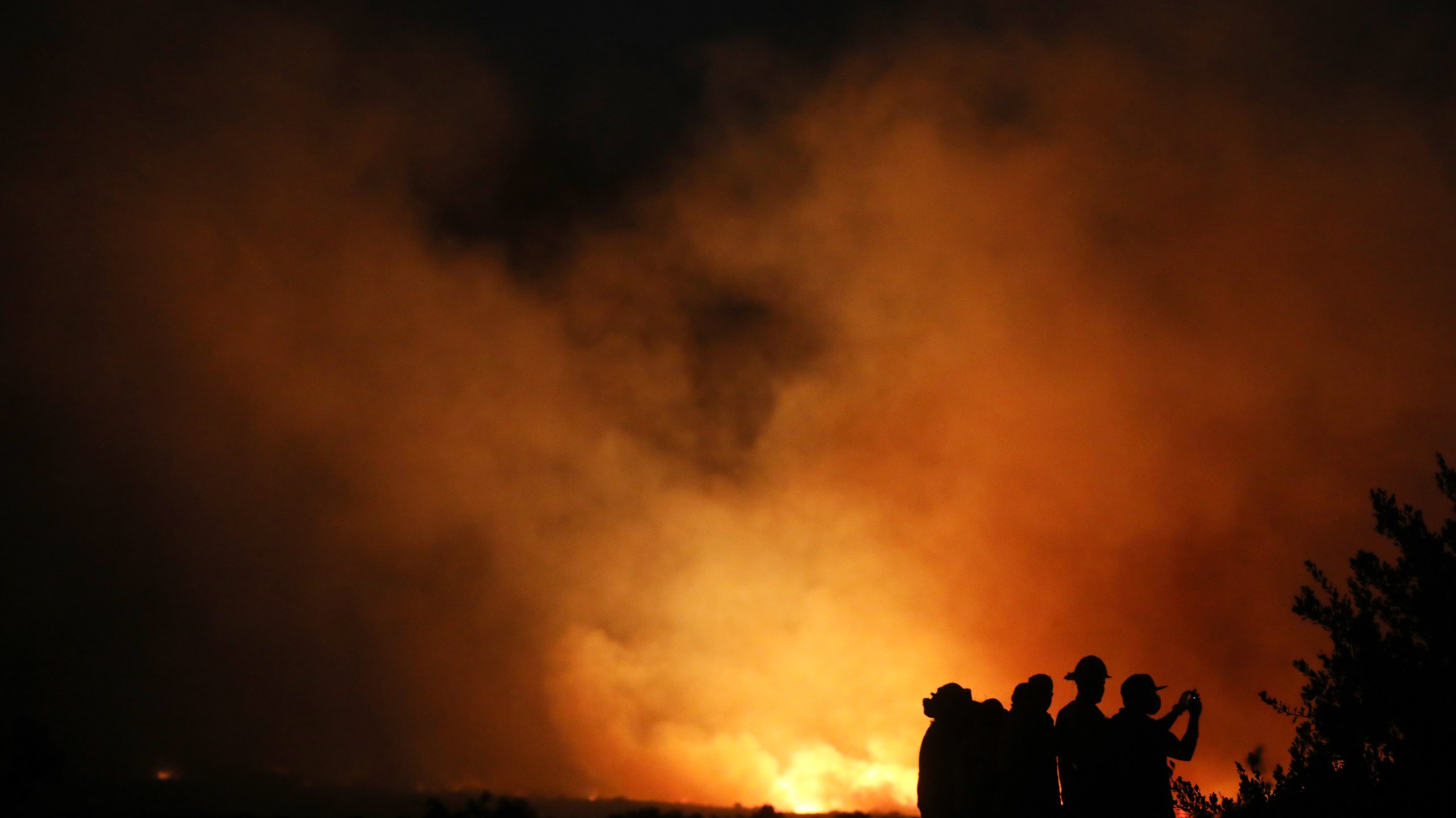 Firefighters and onlookers gather during the Silverado Fire in Orange County on Oct. 26, 2020, in Lake Forest. (Mario Tama/Getty Images)