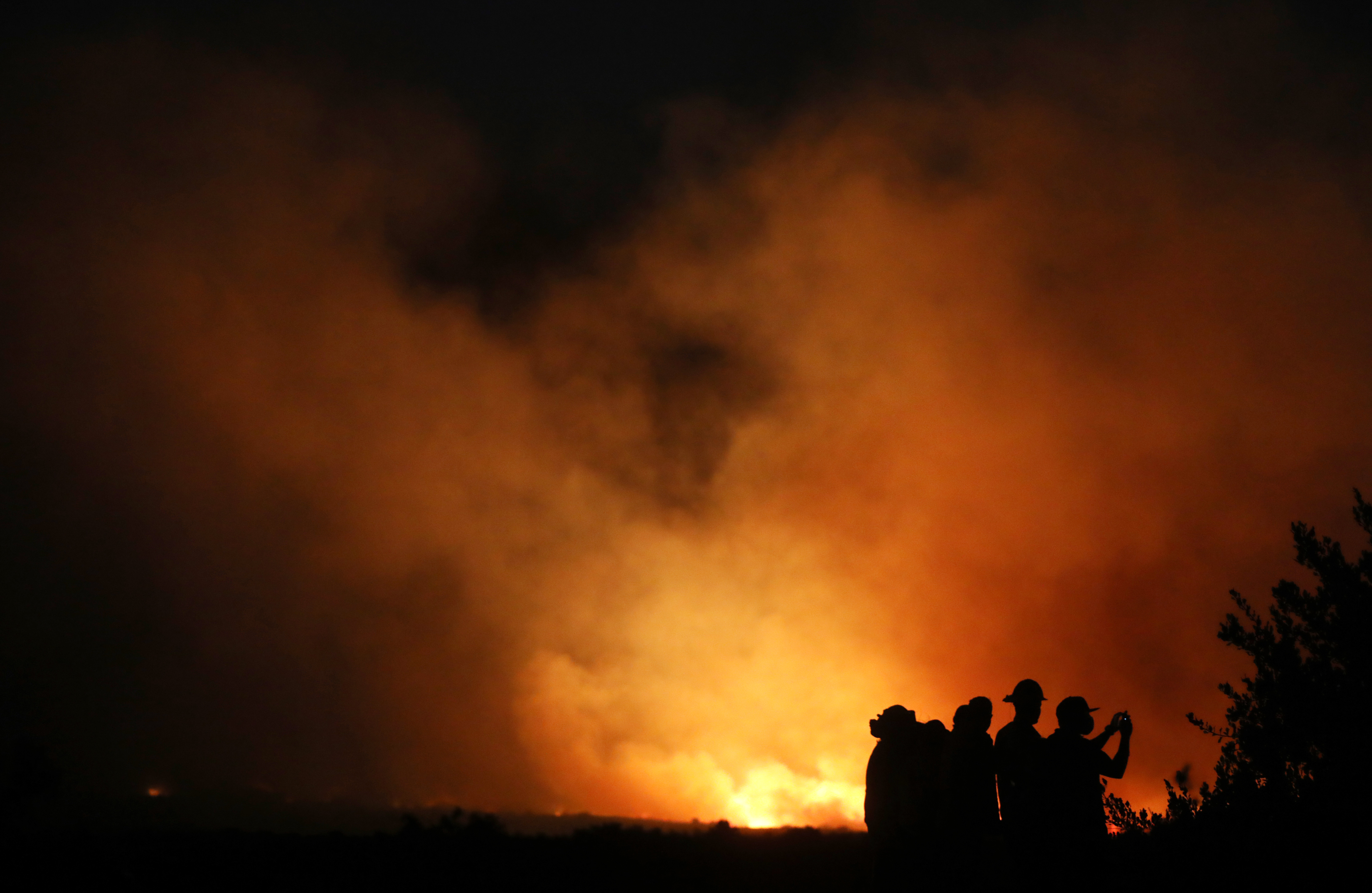 Firefighters and onlookers gather during the Silverado Fire in Orange County on Oct. 26, 2020, in Lake Forest. (Mario Tama/Getty Images)