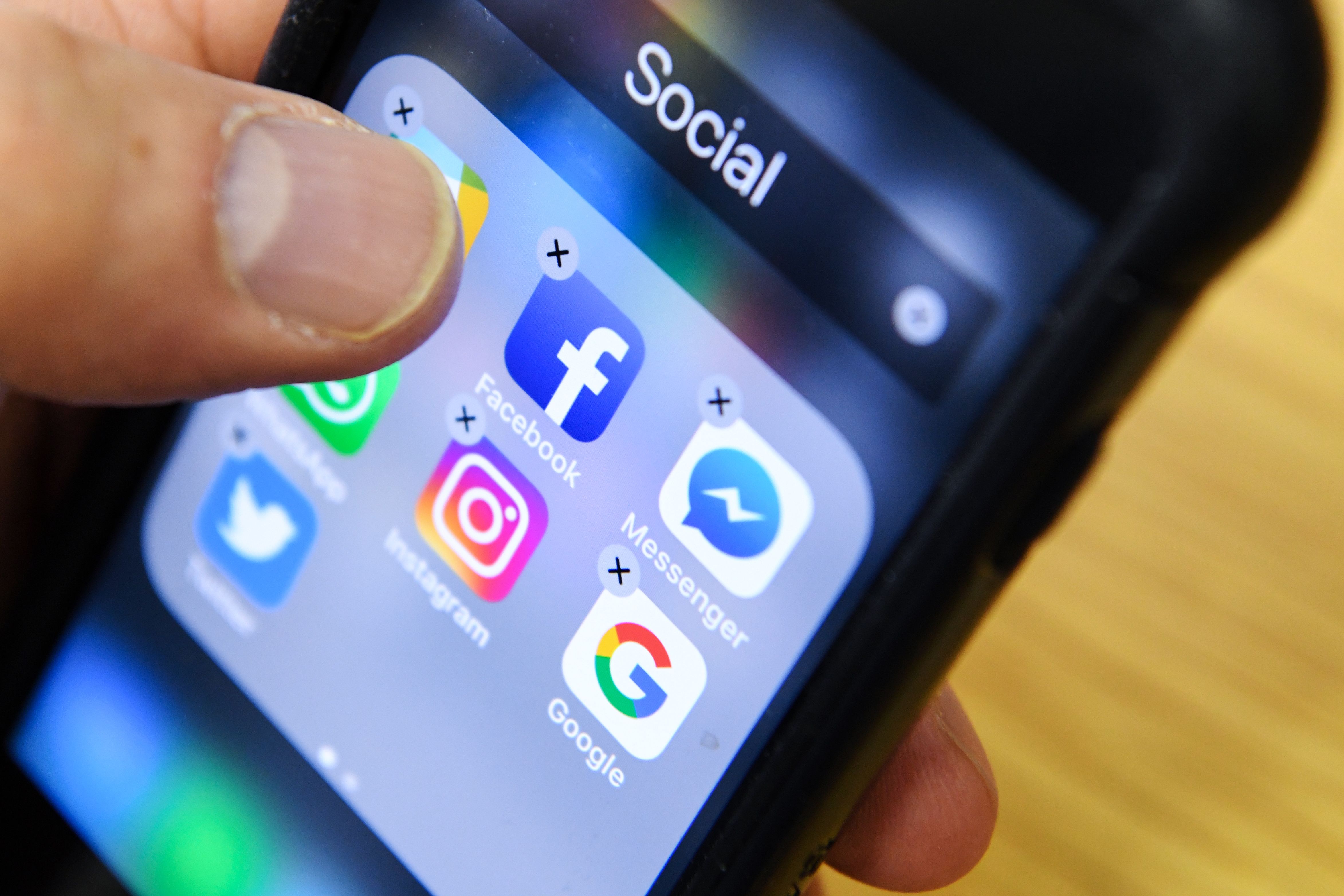 A man holds a smart phone with the icons for the social networking apps Facebook, Instagram and Twitter seen on the screen in Moscow on March 23, 2018. (KIRILL KUDRYAVTSEV/AFP via Getty Images)