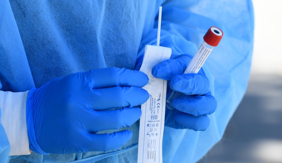 A medical worker holds a coronavirus test kit on Aug. 10, 2020 in Winnetka, California. (Kevin Winter/Getty Images)