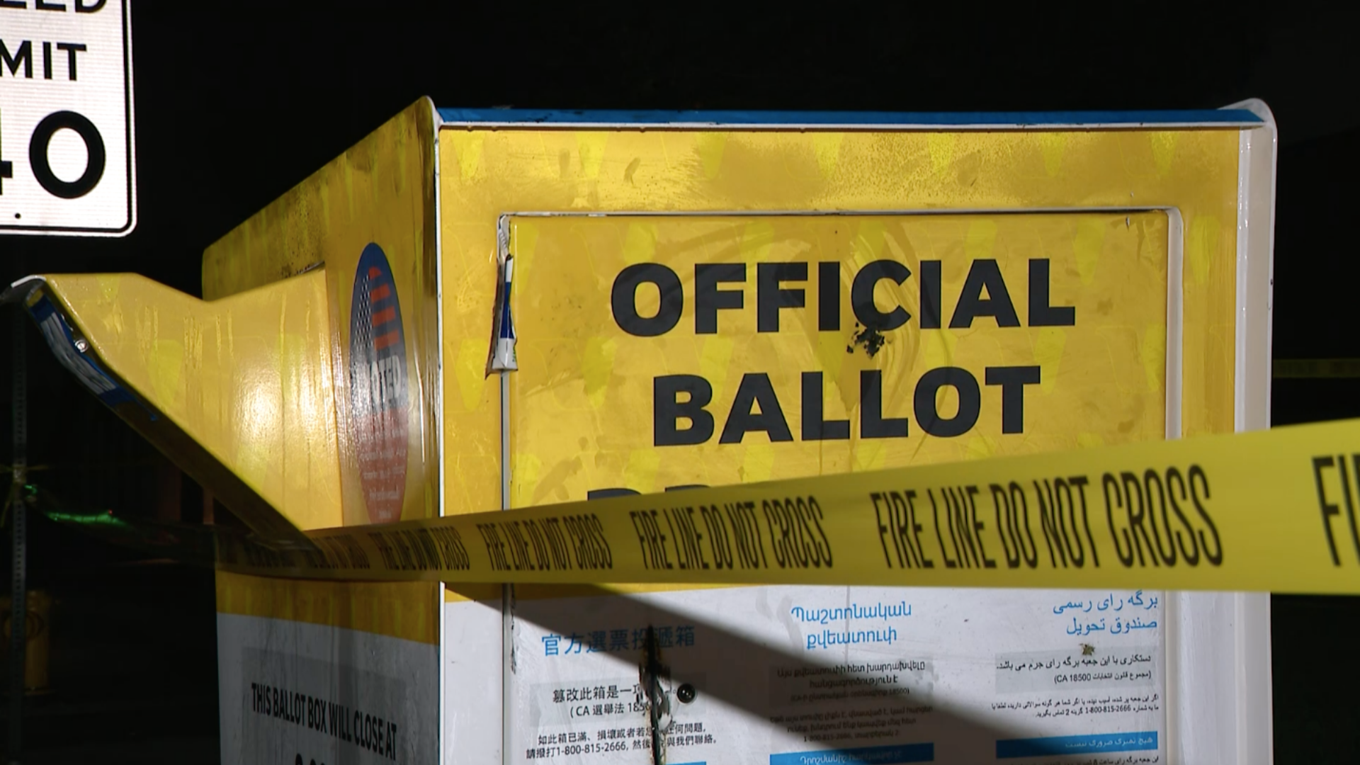 A tape that reads "fire line do not cross" is seen around an official ballot drop box outside the Baldwin Park Library on Oct. 19, 2020. (KTLA)