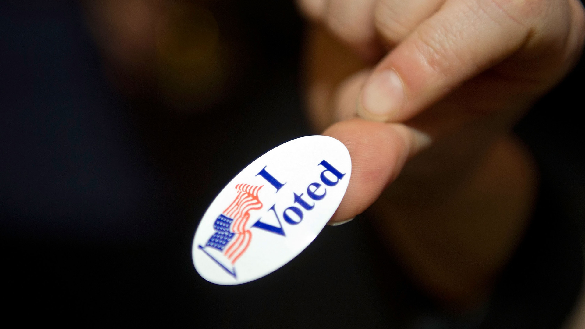 A person displays an "I Voted" sticker. (Photo by Bethany Clarke/Getty Images)