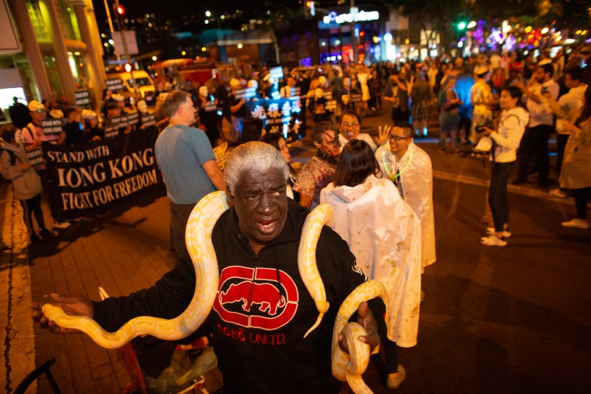 Ronald Johnson shows off his snake at the 2019 annual West Hollywood Carnaval along Santa Monica Boulevard. This year’s event has been canceled because of the pandemic.(Jason Armond / Los Angeles Times)