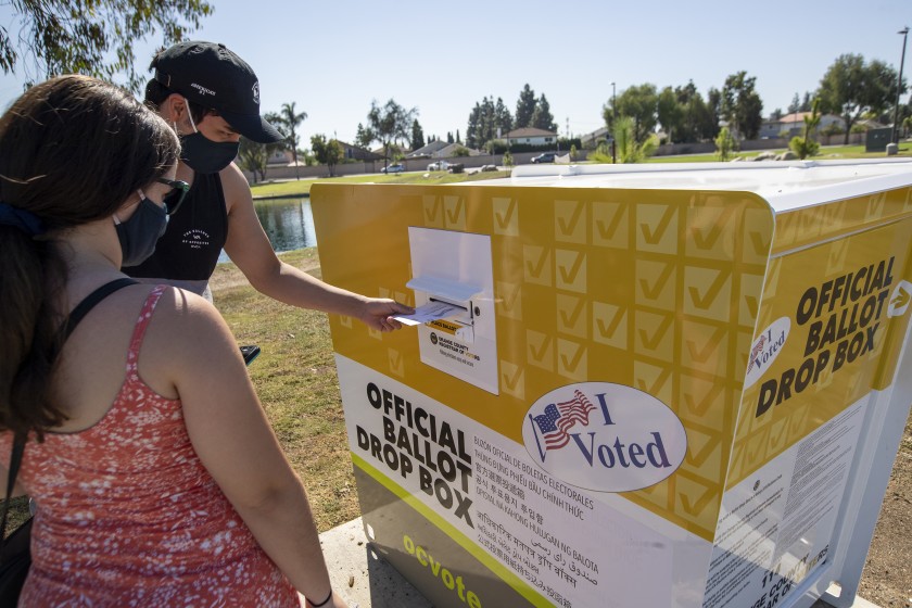 Voters place their ballots inside an official ballot drop box at Carl Thornton Park in Santa Ana in this undated photo. (Allen J. Schaben / Los Angeles Times)