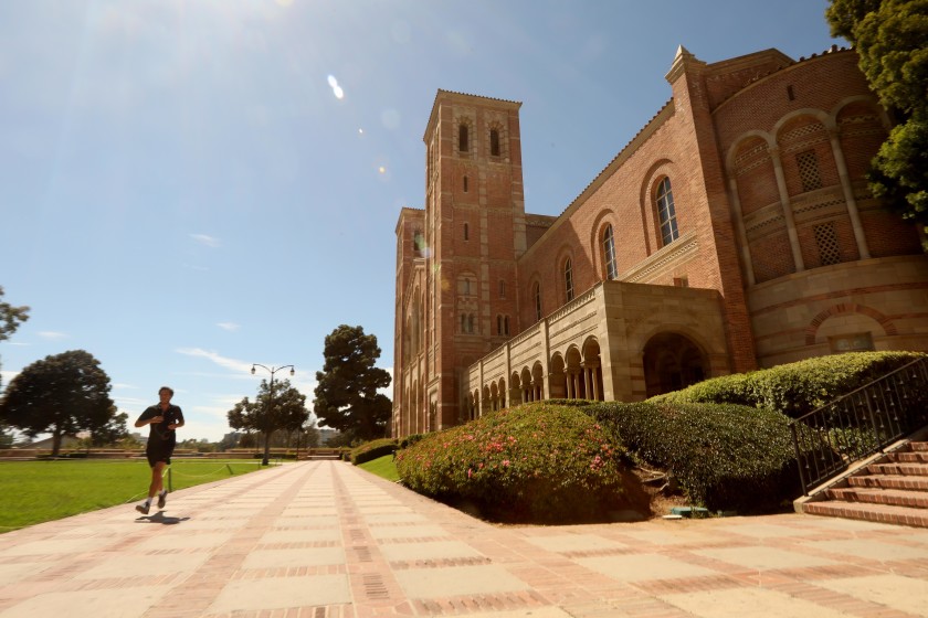 A lone jogger runs past Royce Hall on a nearly empty UCLA campus in Los Angeles on Aug. 13. (Genaro Molina/Los Angeles Times)