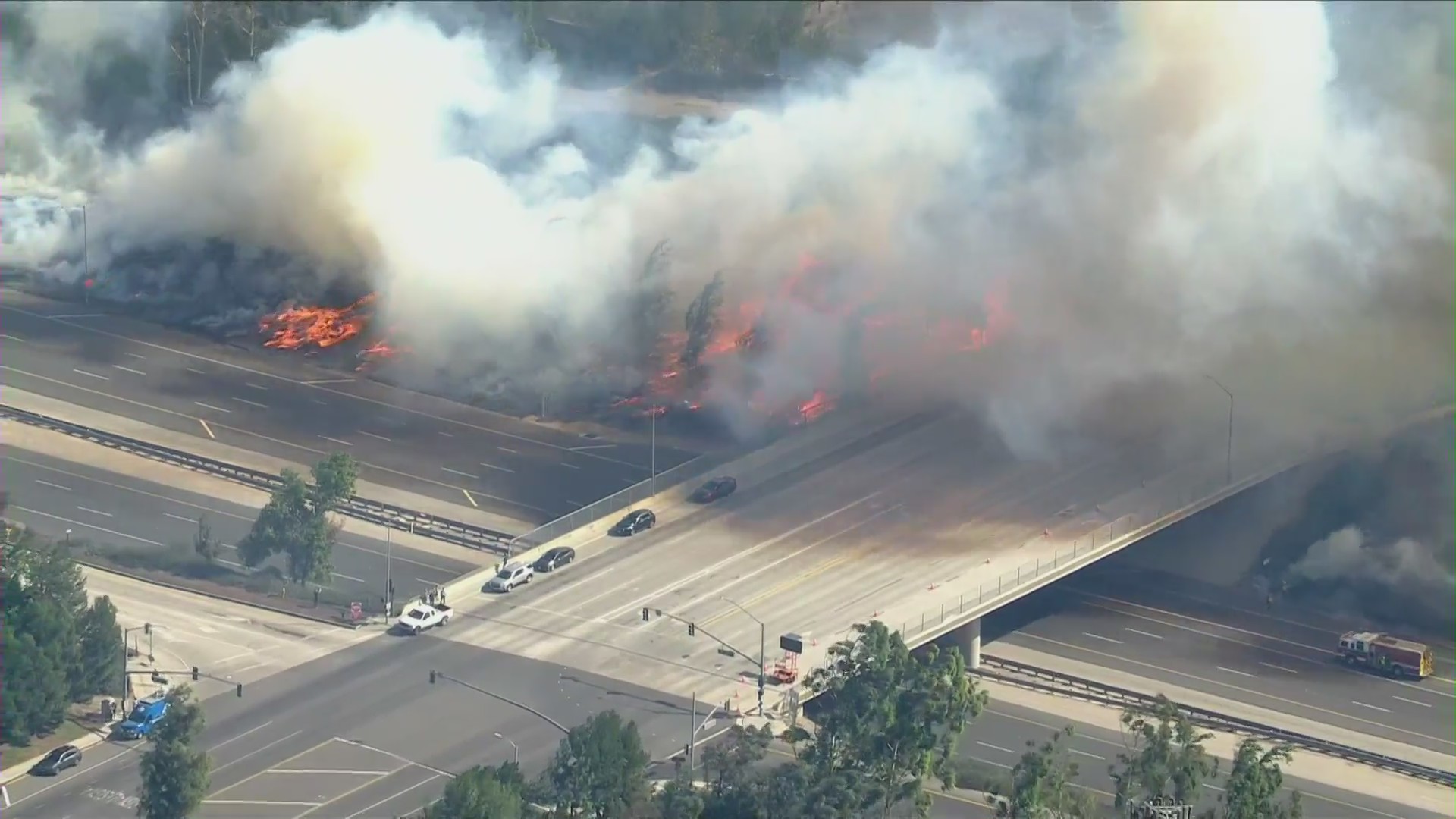 Flames rage near the Irvine Boulevard overpass above the 133 in Irvine as the Silverado Fire burns on Oct. 26, 2020. (KTLA)