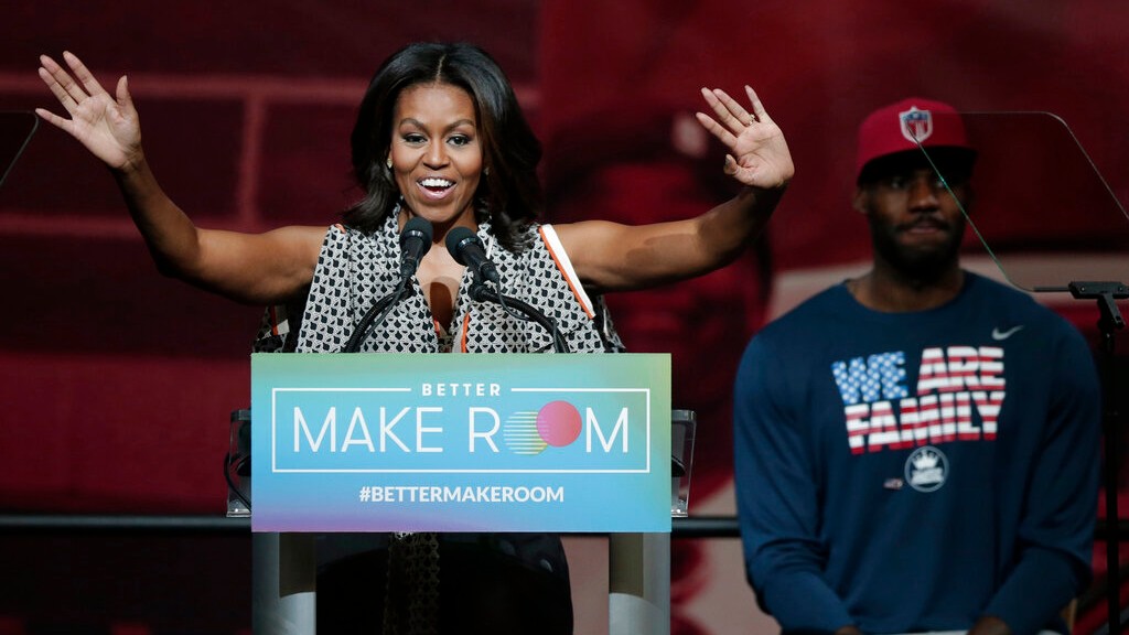 In this Oct. 21, 2015, file photo, former first lady Michelle Obama speaks at the University of Akron as NBA star LeBron James listens in rear, in Akron, Ohio. (AP Photo/Tony Dejak, File)