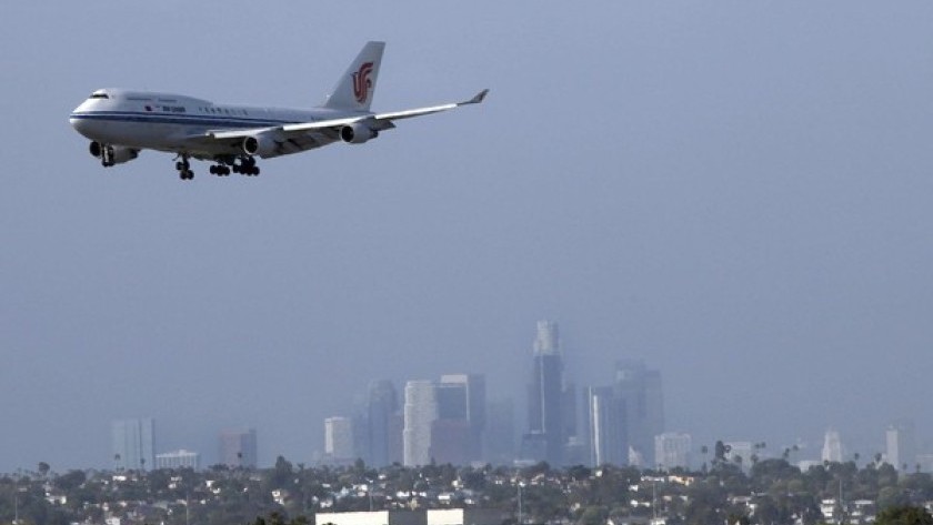 A plane approaches LAX for a landing with downtown Los Angeles in the background.(Michael Robinson Chavez / Los Angeles Times)