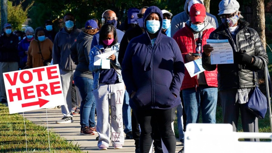 Early voters line up to cast their ballots at the South Regional Library polling location in Durham, N.C., Thursday, Oct. 15, 2020. (AP Photo/Gerry Broome)