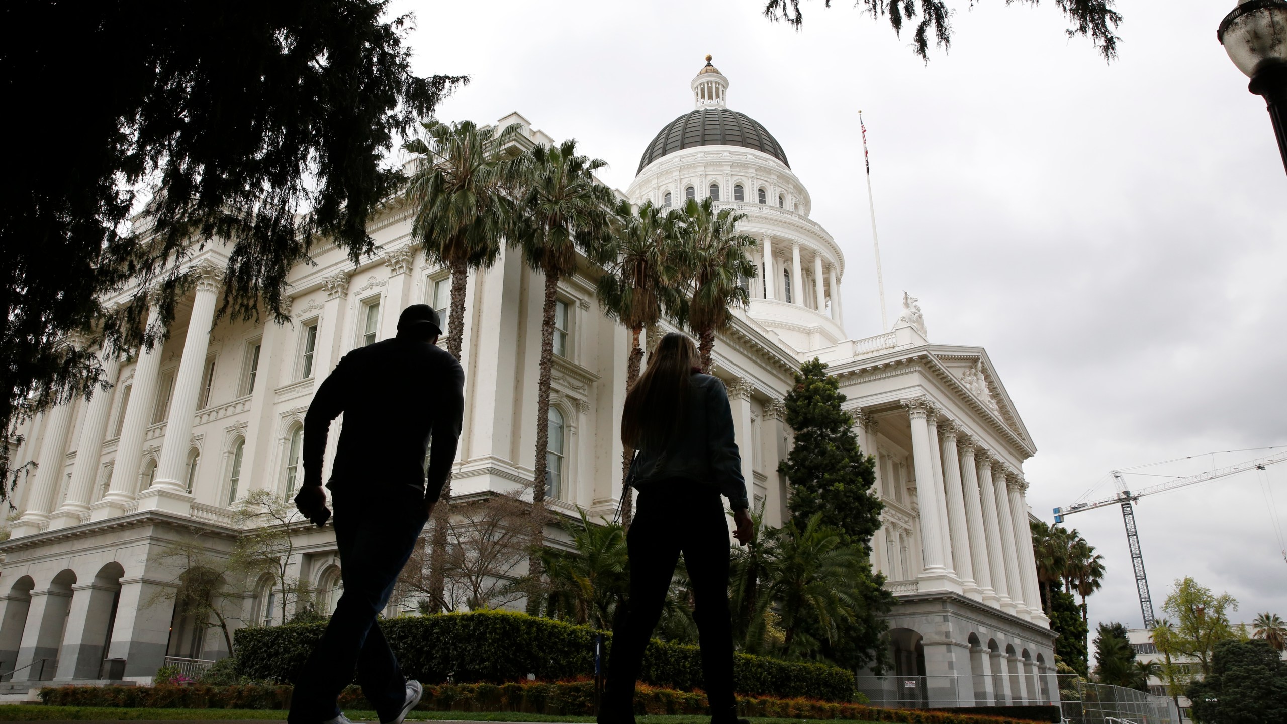 People walk near the state Capitol in Sacramento on March 18, 2020. (Rich Pedroncelli / Associated Press)