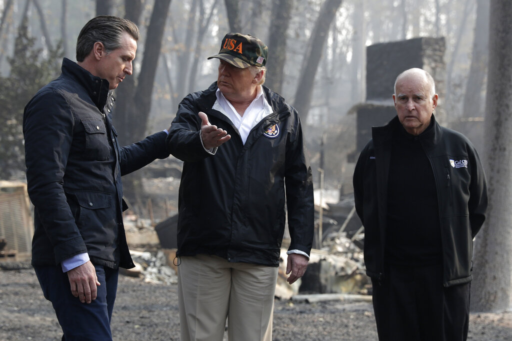 President Donald Trump talks with Gov. Gavin Newsom, left, and as then-Gov. Jerry Brown listens during a visit to a neighborhood impacted by the wildfires in Paradise on Nov. 17, 2018. (AP Photo/Evan Vucci, File)