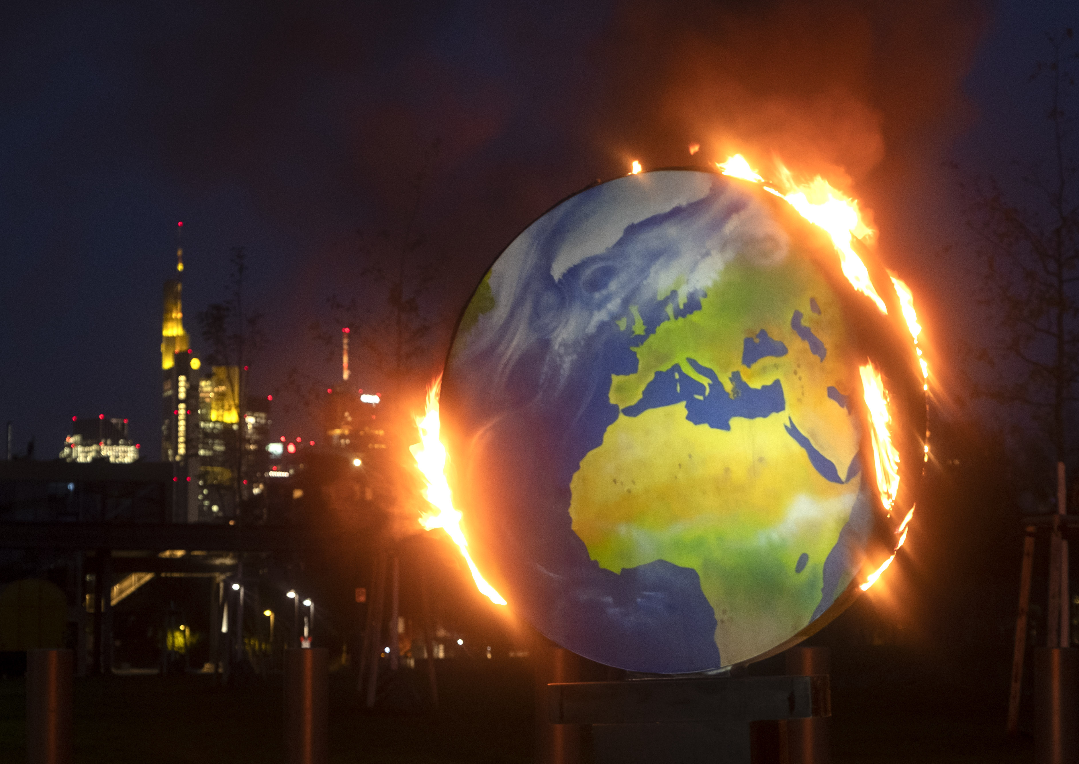 A makeshift globe burns in front of the European Central Bank in Frankfurt, Germany, Wednesday, Oct. 21, 2020. (AP Photo/Michael Probst)