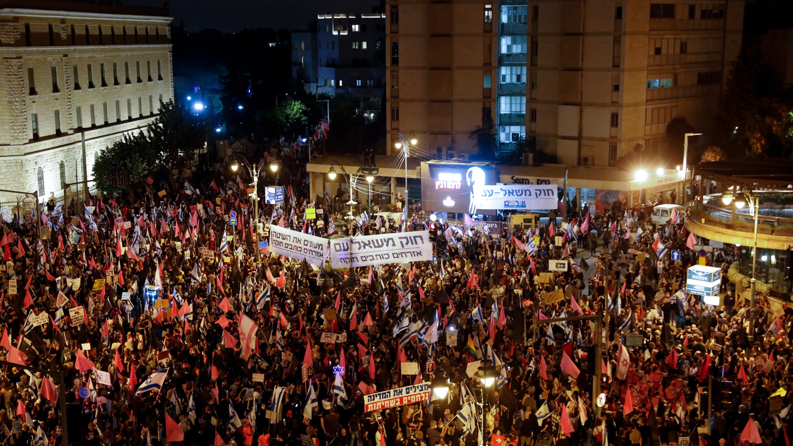 Protesters chant slogans and hold signs during a protest against Israel's Prime Minister Benjamin Netanyahu in Jerusalem, Saturday, Oct. 31, 2020. (Ariel Schalit/AP Photo)