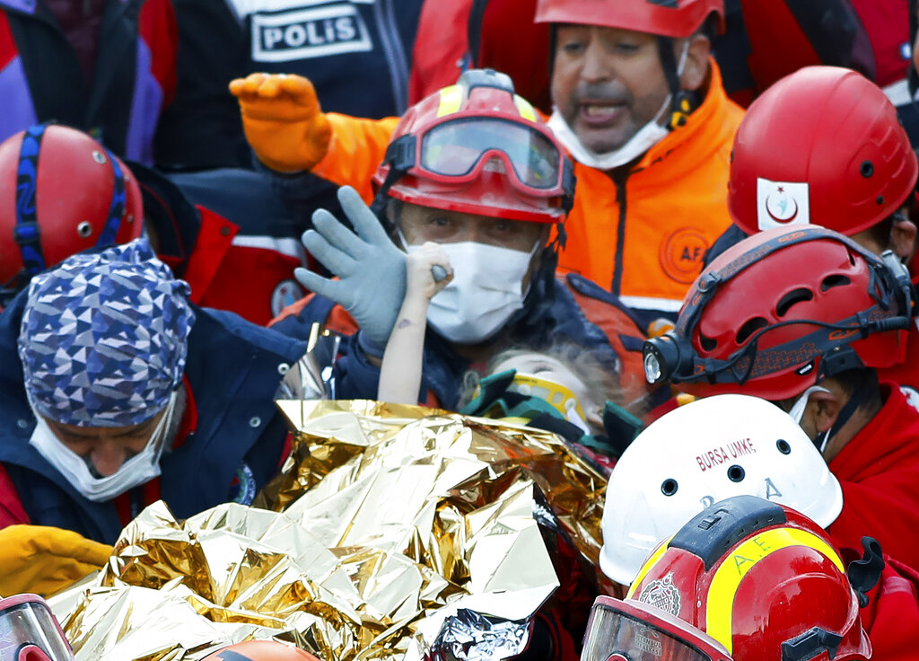 In this handout photo made available by the Istanbul Fire Authority, members of various rescue services carry 3-year-old girl Elif Perincek, after she was rescued from the rubble of a building some 65 hours after a magnitude 6.6 earthquake in Izmir, Turkey on Nov. 2, 2020. (Istanbul Fire Authority via AP)