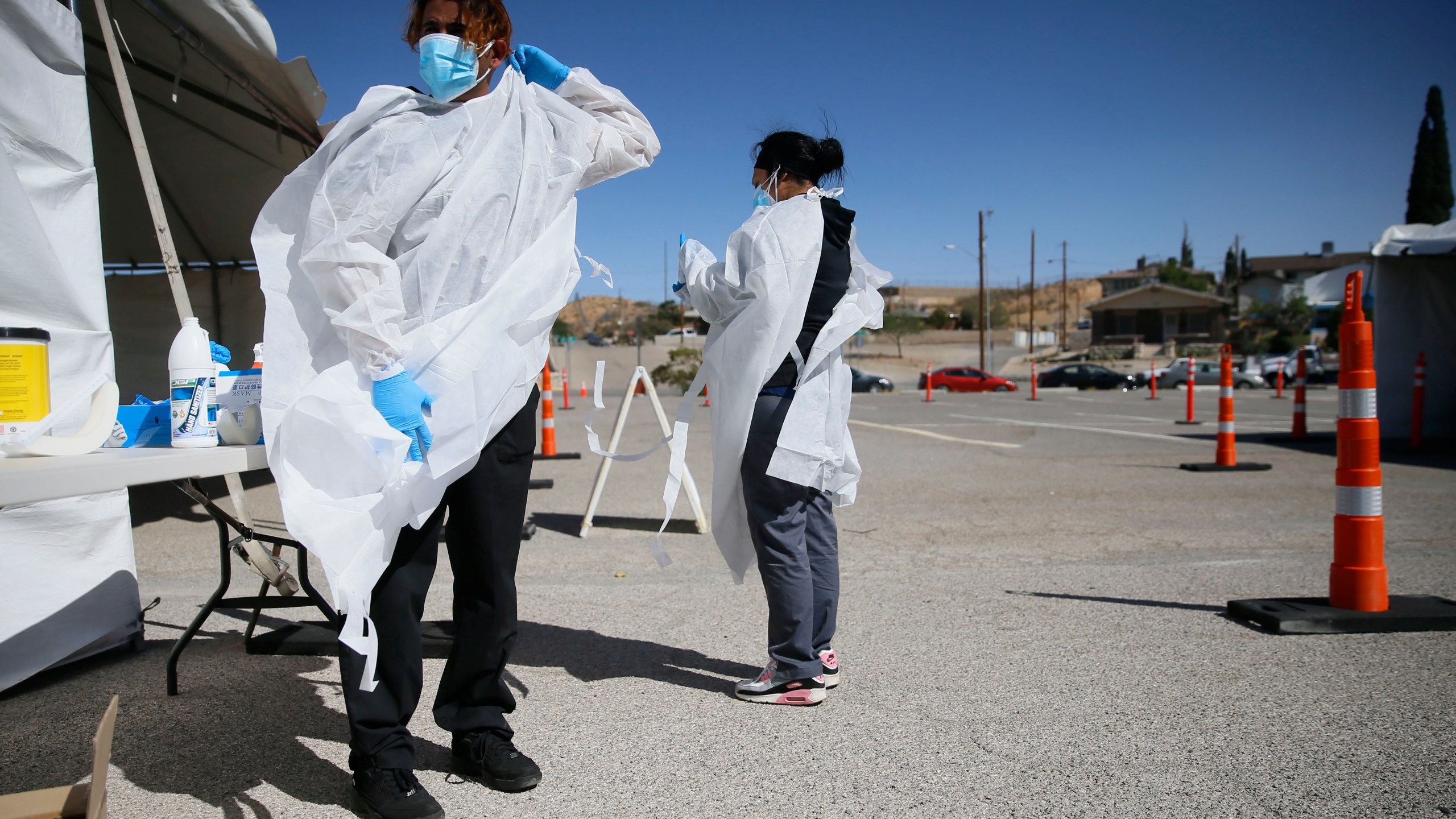 In this Oct. 26, 2020, file photo, Jacob Newberry puts on new PPE at the COVID-19 state drive-thru testing location at UTEP in El Paso, Texas. (Briana Sanchez/The El Paso Times via AP, File)