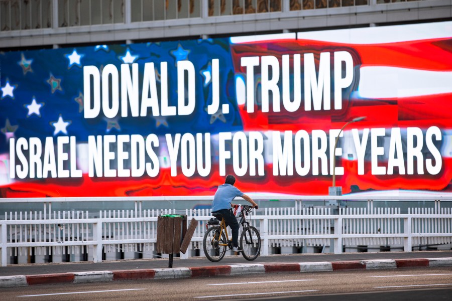 In this Oct. 21, 2020 file photo a cyclist rides next to a billboard supporting President Donald Trump in Tel Aviv ahead of the U.S presidential election. (Oded Balilty/Associated Press)