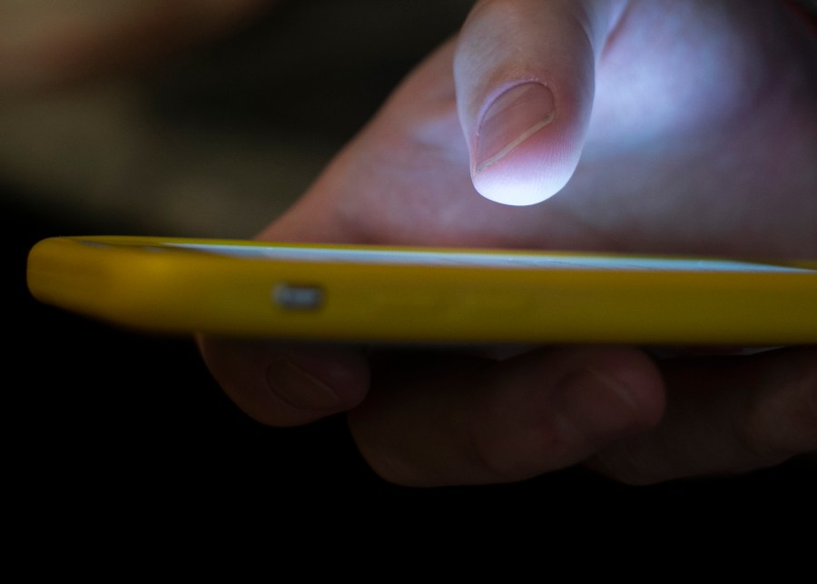 In this Aug. 11, 2019, file photo, a man uses a cellphone in New Orleans. Voters across the U.S. received anonymous robocalls in the days and weeks before Election Day urging them to “stay safe and stay home” — an ominous warning that election experts said could be an effort to scare voters into sitting out the election. (AP Photo/Jenny Kane, File)