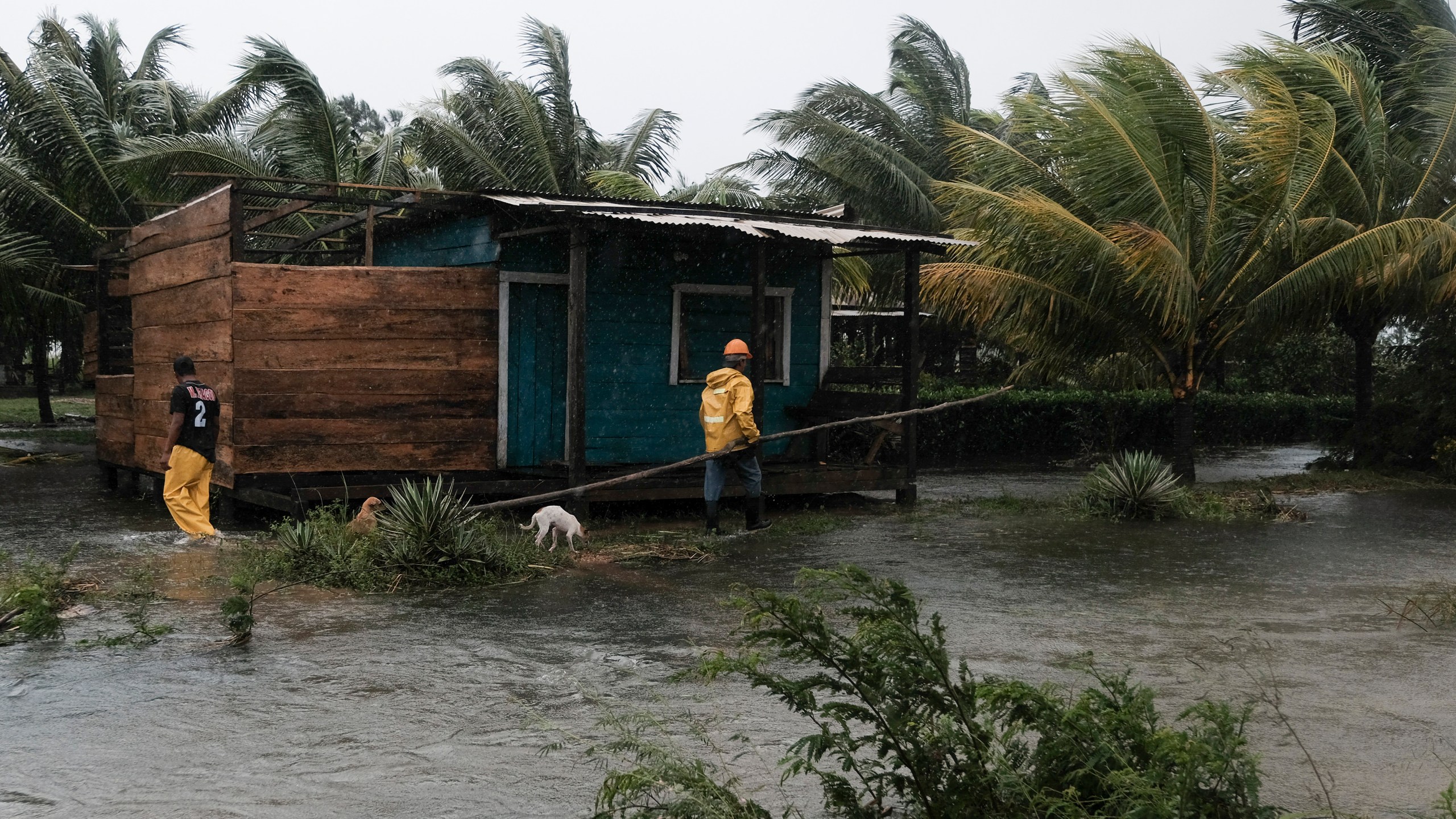 Two men walk around the perimeters of a home surrounded by flood waters brought on by Hurricane Eta in Wawa, Nicaragua on Nov. 3, 2020. (Carlos Herrera/Associated Press)