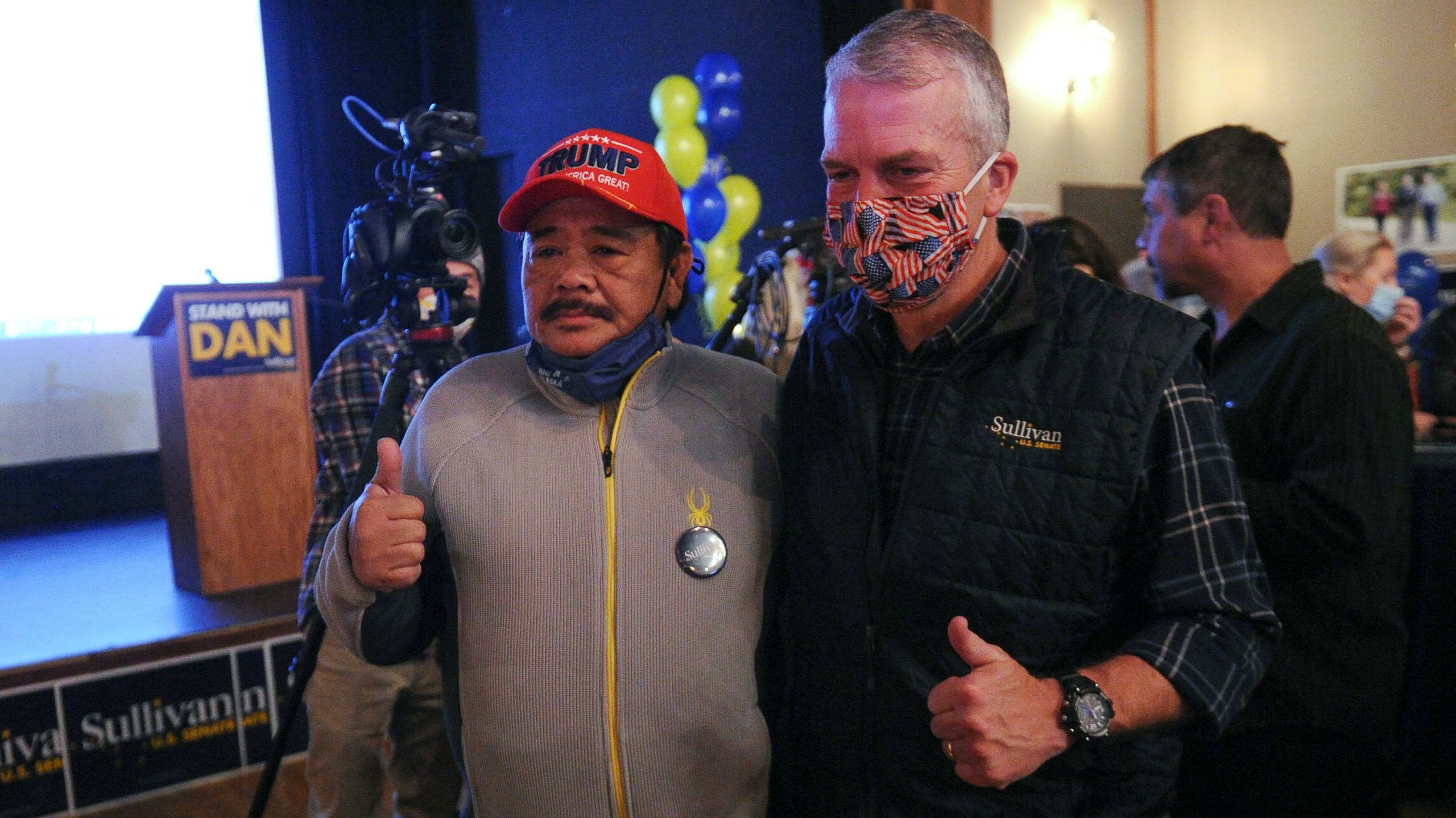 Sen. Dan Sullivan, right front, R-Alaska, poses for a photograph with supporter Rolando Torralba at a campaign party Tuesday, Nov. 3, 2020, in Anchorage, Alaska. (AP Photo/Michael Dinneen)