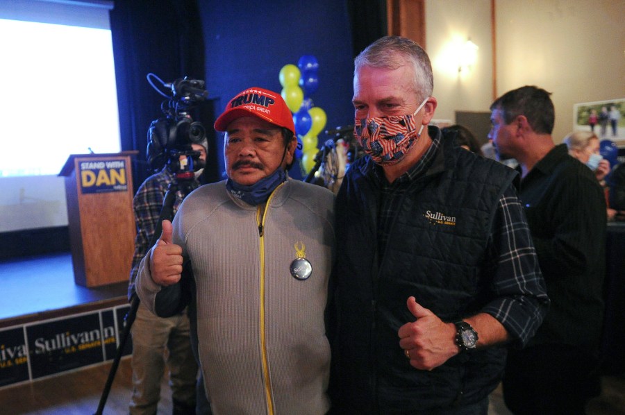 Sen. Dan Sullivan, right front, R-Alaska, poses for a photograph with supporter Rolando Torralba at a campaign party Tuesday, Nov. 3, 2020, in Anchorage, Alaska. (AP Photo/Michael Dinneen)