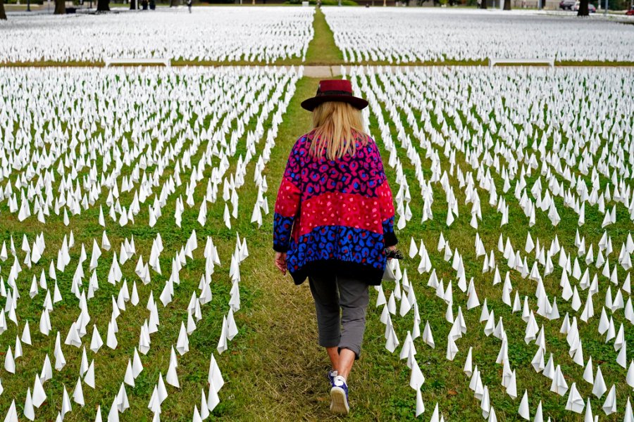 Artist Suzanne Brennan Firstenberg walks among thousands of white flags planted in remembrance of Americans who have died of COVID-19 near Robert F. Kennedy Memorial Stadium in Washington on Oct. 27, 2020. (AP Photo/Patrick Semansky, File)