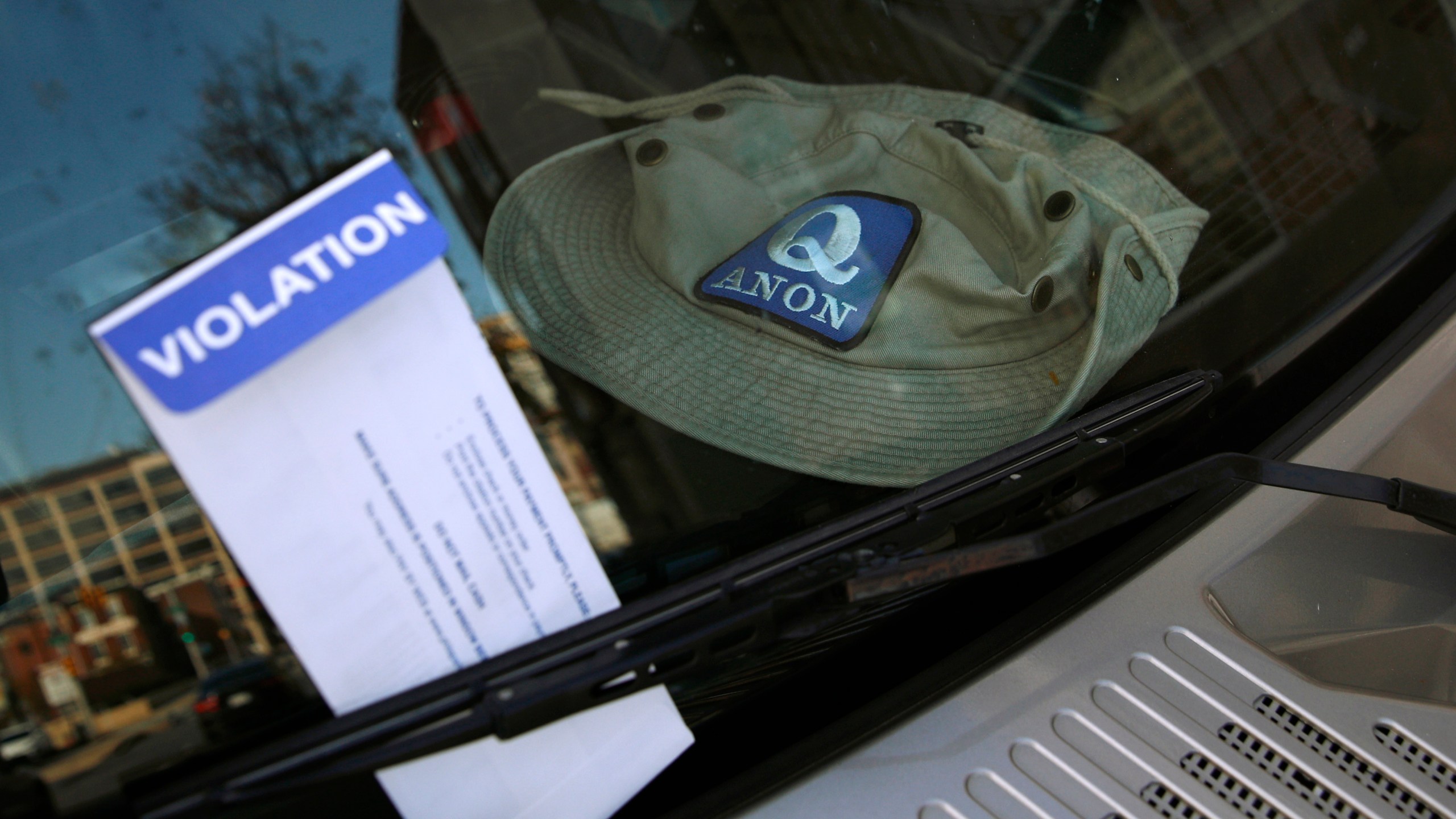 A parking violation envelope is affixed to the windshield of a Hummer vehicle parked near the Pennsylvania Convention Center where votes are being counted, Friday, Nov. 6, 2020, in Philadelphia. Police said Friday they arrested two men Thursday for not having permits to carry firearms near the center. Police said the men acknowledged that the Hummer spotted by officers near the center was was their vehicle. (AP Photo/Rebecca Blackwell)