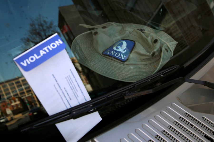 A parking violation envelope is affixed to the windshield of a Hummer vehicle parked near the Pennsylvania Convention Center where votes are being counted, Friday, Nov. 6, 2020, in Philadelphia. Police said Friday they arrested two men Thursday for not having permits to carry firearms near the center. Police said the men acknowledged that the Hummer spotted by officers near the center was was their vehicle. (AP Photo/Rebecca Blackwell)