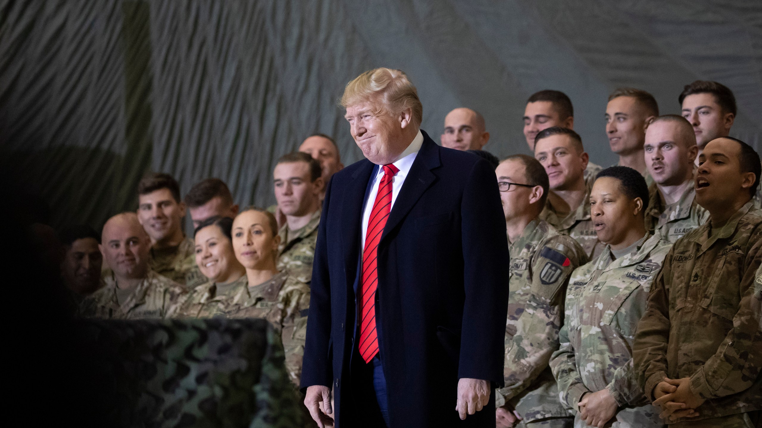 In this Nov. 28, 2019, file photo President Donald Trump smiles before addressing members of the military during a surprise Thanksgiving Day visit at Bagram Air Field, Afghanistan. Trump has held himself up as a champion of U.S. troops without rival. Now, with his presidency on the line, he’s casting suspicion on a tool of participatory democracy, the mail-in ballot, that has allowed U.S. military personnel to participate in elections while serving far from home since the War of 1812. (AP Photo/Alex Brandon, File)