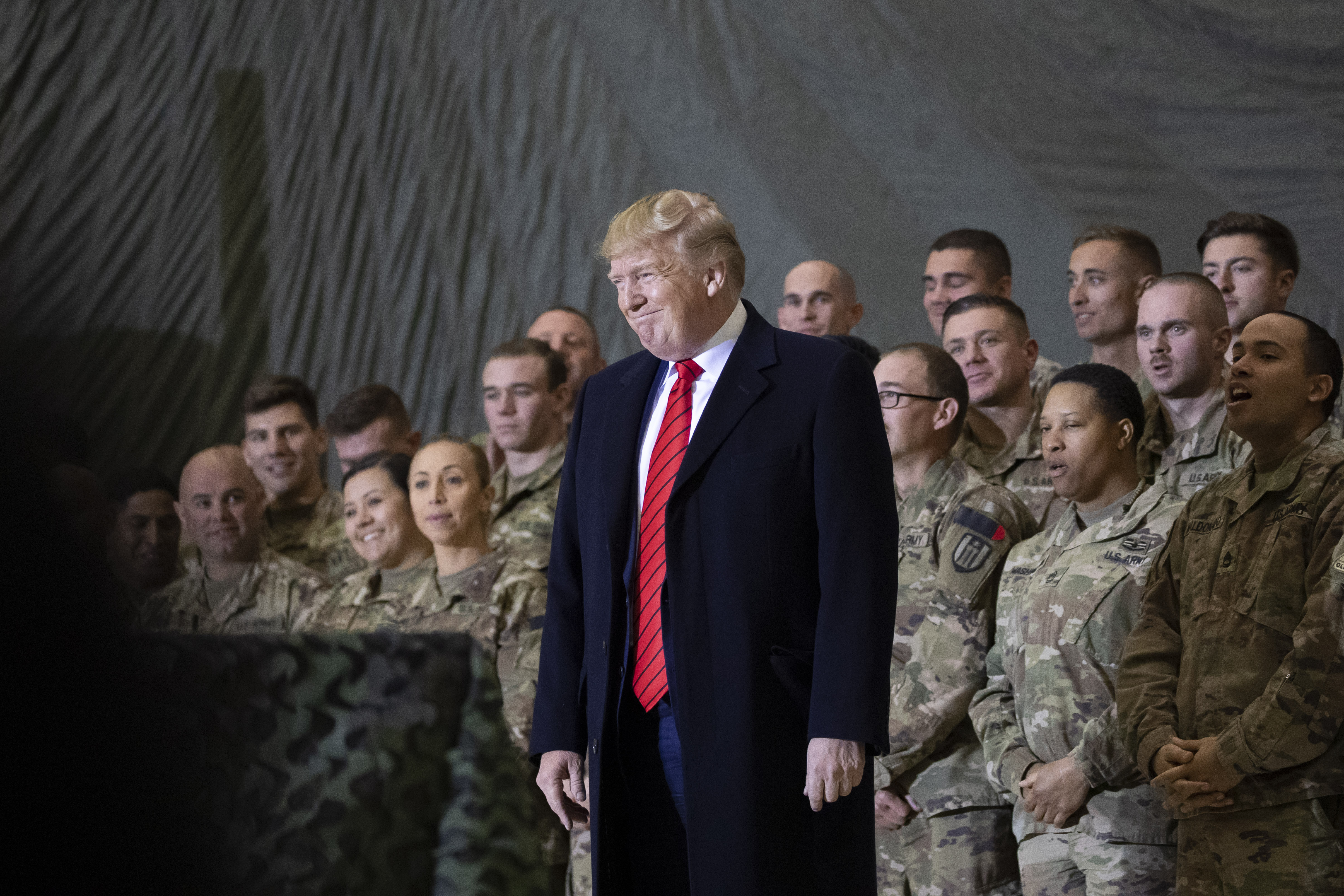 In this Nov. 28, 2019, file photo President Donald Trump smiles before addressing members of the military during a surprise Thanksgiving Day visit at Bagram Air Field, Afghanistan. Trump has held himself up as a champion of U.S. troops without rival. Now, with his presidency on the line, he’s casting suspicion on a tool of participatory democracy, the mail-in ballot, that has allowed U.S. military personnel to participate in elections while serving far from home since the War of 1812. (AP Photo/Alex Brandon, File)