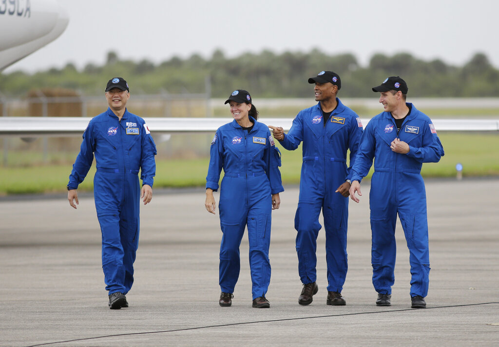 Astronaut Soichi Noguchi, of Japan, from left, NASA Astronauts Shannon Walker, Victor Glover and Michael Hopkins walk after arriving at Kennedy Space Center, Sunday, Nov. 8, 2020, in Cape Canaveral, Fla. The four astronauts will fly on the SpaceX Crew-1 mission to the International Space Station scheduled for launch on Nov. 14, 2020 (AP Photo/Terry Renna)