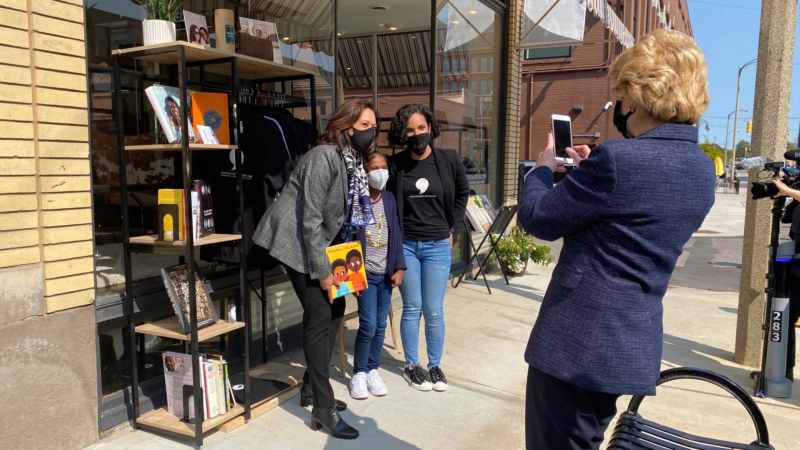 Michigan Sen. Debbie Stabenow, right, takes a picture of Vice President-elect Kamala Harris posing for a photo on Sept. 22, 2020 with Egypt Otis and her nine-year-old daughter Eva Allen in front of their downtown Flint, Mich., bookstore, the Comma Bookstore & Social Hub. (AP Photo/Katrease Stafford)