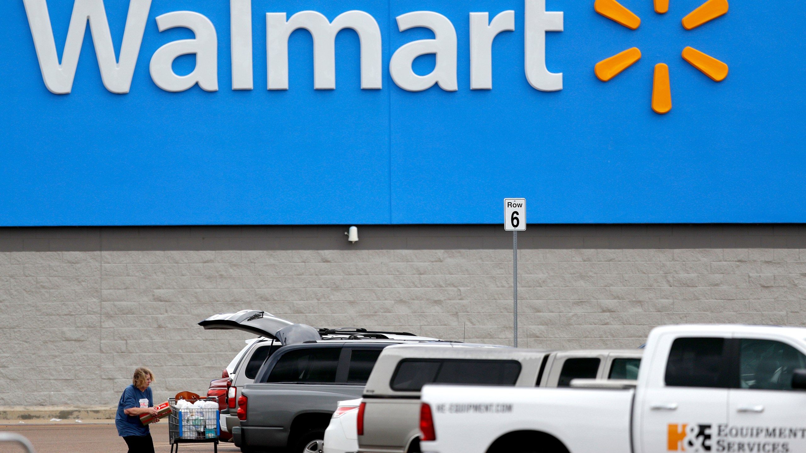 In this March 31, 2020 file photo, a woman pulls groceries from a cart to her vehicle outside of a Walmart store in Pearl, Miss. (Julio Cortez/AP Photo)