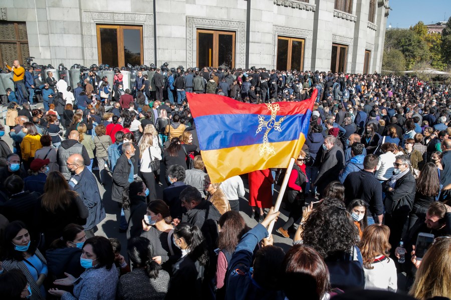 Protesters wave an Armenian national flag during a protest against an agreement to halt fighting over the Nagorno-Karabakh region, in Yerevan, Armenia, Wednesday, Nov. 11, 2020. (AP Photo/Dmitri Lovetsky)