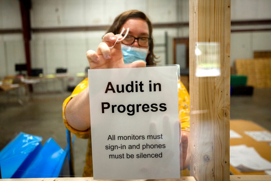 A Chatham County election official posts a sign in the public viewing area before the start of a ballot audit, Friday, Nov. 13, 2020, in Savannah, Ga. (AP Photo/Stephen B. Morton)