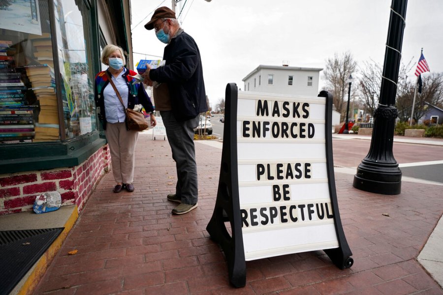 Shoppers comply with the mask regulations to help prevent the spread of the coronavirus at Bridgton Books on Nov. 13, 2020, in Bridgton, Maine. (AP Photo/Robert F. Bukaty)