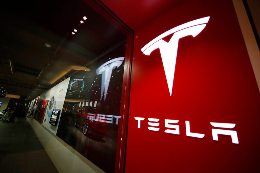 In this Feb. 9, 2019, file photo, a sign bearing the company logo stands outside a Tesla store in Cherry Creek Mall in Denver. (AP Photo/David Zalubowski, File)