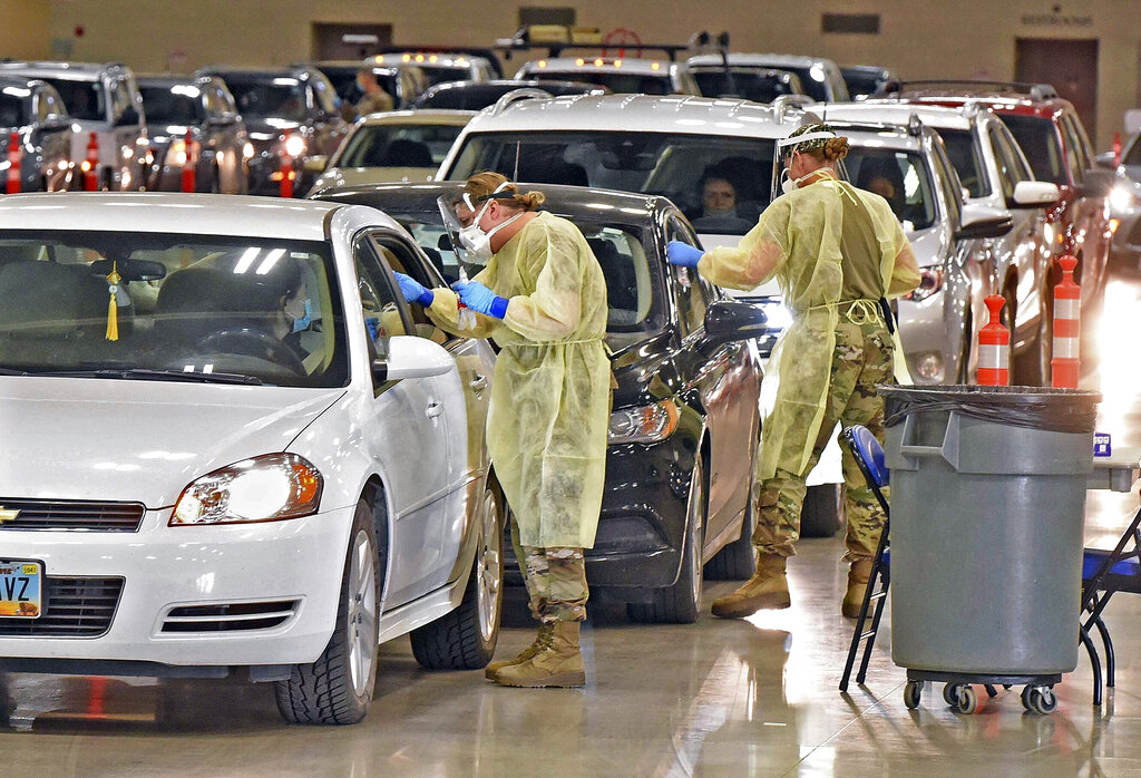 In this Nov. 17, 2020, file photo, North Dakota National Guard soldiers administer coronavirus tests inside the Bismarck Events Center in Bismarck, N.D. (Tom Stromme/The Bismarck Tribune via AP, File)