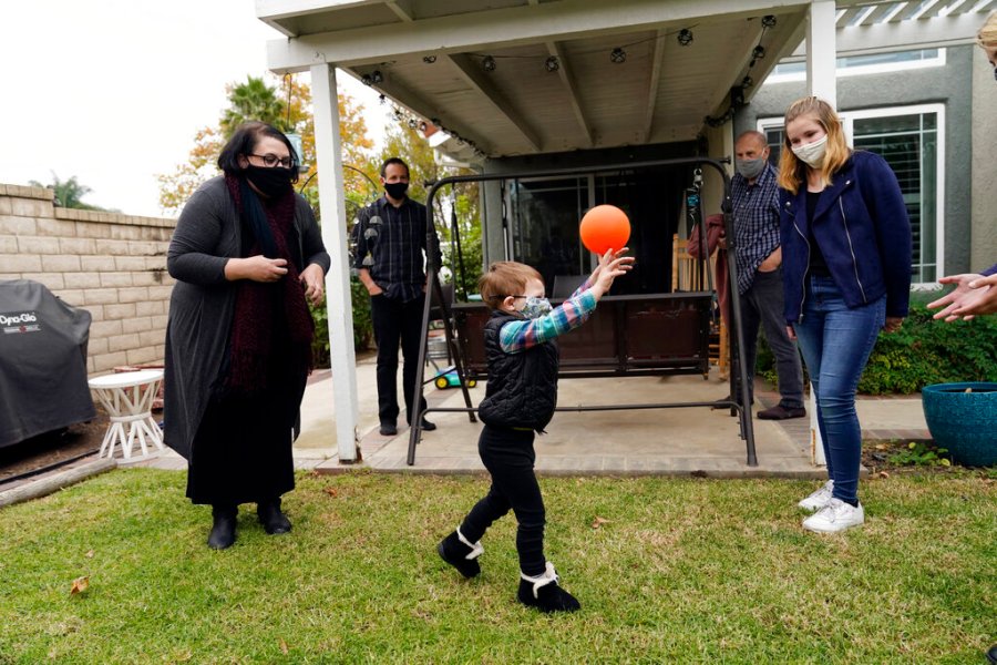 The Schmidt family, from, left, Heather Schmidt, her husband Nicholas Philbrook, son Andrew, 4, father Raymond and daughter Ava are seen in their backyard on Nov. 18, 2020, in Camarillo, Calif. Philbrook and his wife have been trying to convince court officials that he should be excused from jury duty because her father, a cancer survivor with diabetes, lives with them. But court officials told him that is not a valid reason and he must appear in court in early December. (AP Photo/Marcio Jose Sanchez)