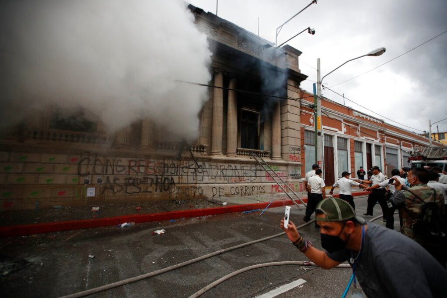 Clouds of smoke shoot out from the Congress building after protesters set it on fire, in Guatemala City, on Nov. 21, 2020. (AP Photo/Moises Castillo)