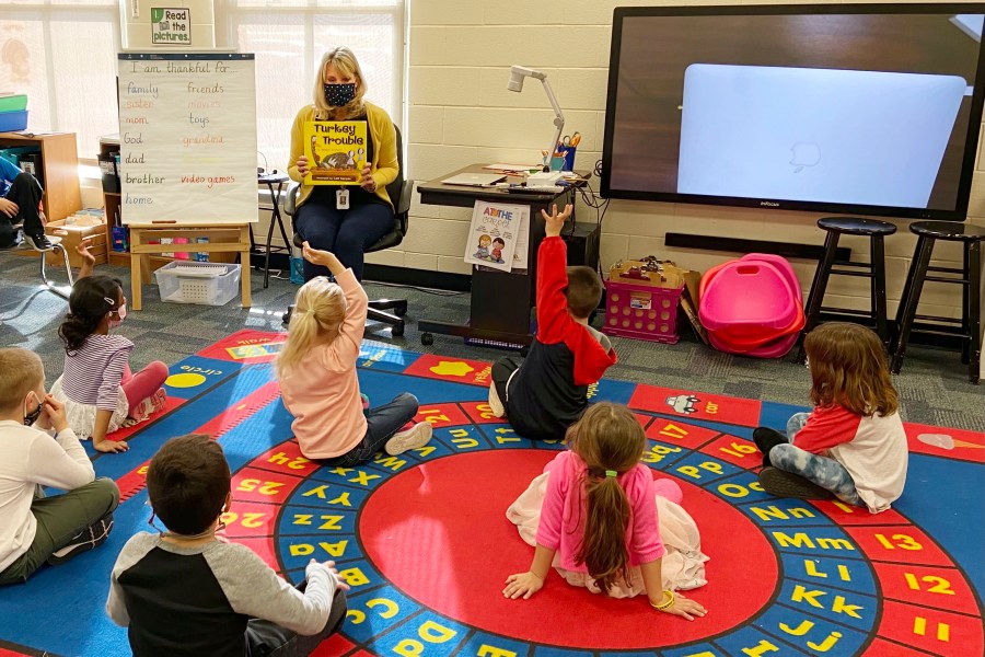 In this photo provided by Julie Mackett, the kindergarten teacher conducts her class at Ft. Meigs Elementary School, in Perrysburg, Ohio. Contact tracing and isolation protocols meant to contain the spread of the coronavirus are sidelining school employees and frustrating efforts to continue in-person learning. “I think everybody understands when you can’t have enough subs to fill the roles, it’s also a safety issue: You can’t have that many children without support from adults,” said Mackett, who went through her own two-week quarantine early in the school year after a student tested positive. (Courtesy of Julie Mackett via AP)