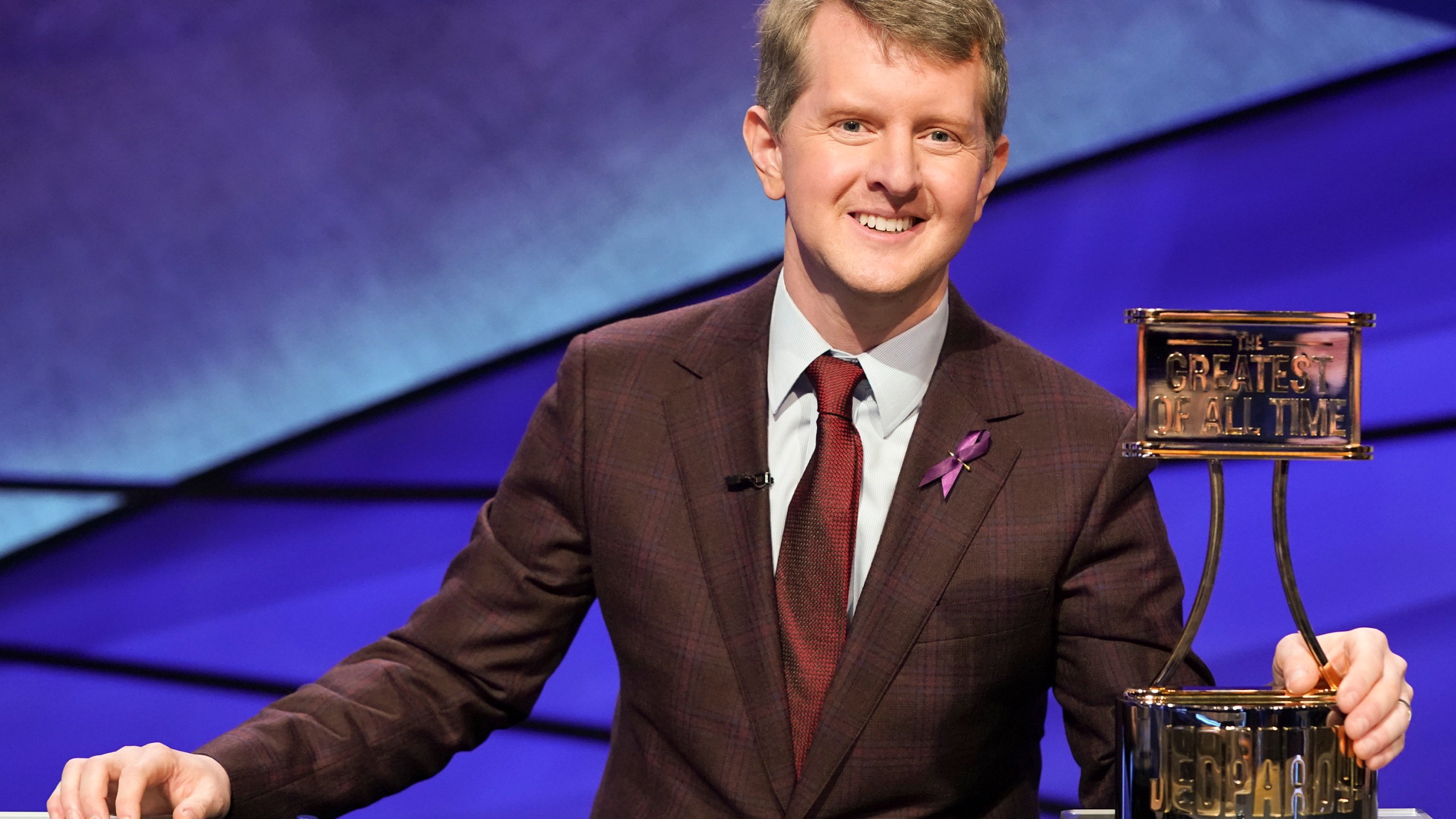 This image released by ABS shows contestant Ken Jennings with a trophy on "JEOPARDY! The Greatest of All Time." (Eric McCandless / ABC via Associated Press)