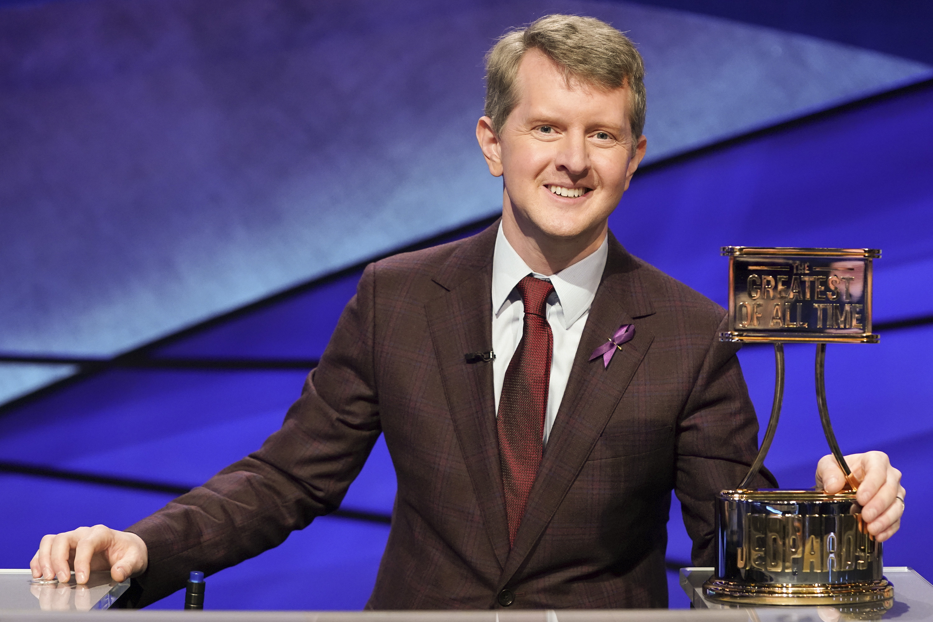 This image released by ABS shows contestant Ken Jennings with a trophy on "JEOPARDY! The Greatest of All Time." (Eric McCandless / ABC via Associated Press)