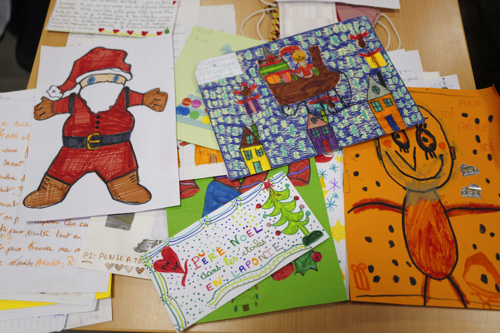 Envelopes addressed to "Pere Noel" - Father Christmas in French - decorated with love hearts, stickers and glitter, are displayed by postal workers in Libourne, southwest France on Nov. 23, 2020. (AP Photo/Francois Mori)