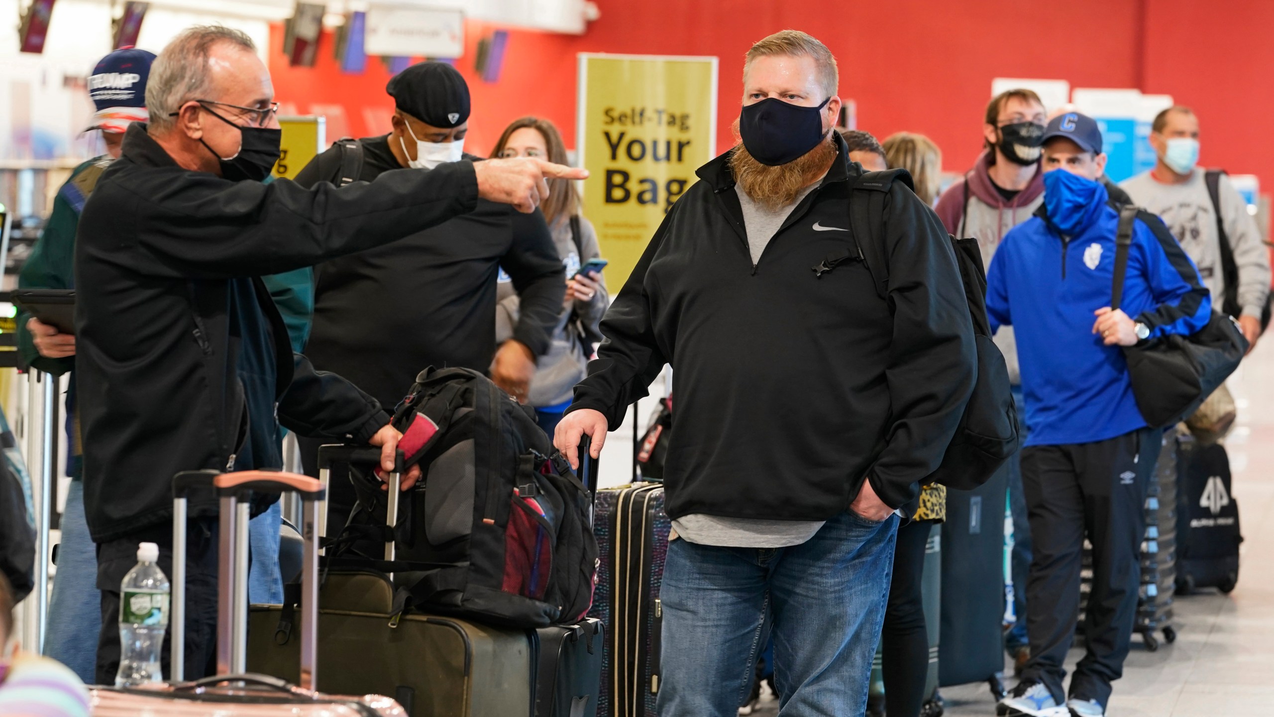 Travelers wait in line at the ticket counter before traveling from Cleveland Hopkins International Airport, Wednesday, Nov. 25, 2020, in Cleveland. (AP Photo/Tony Dejak)