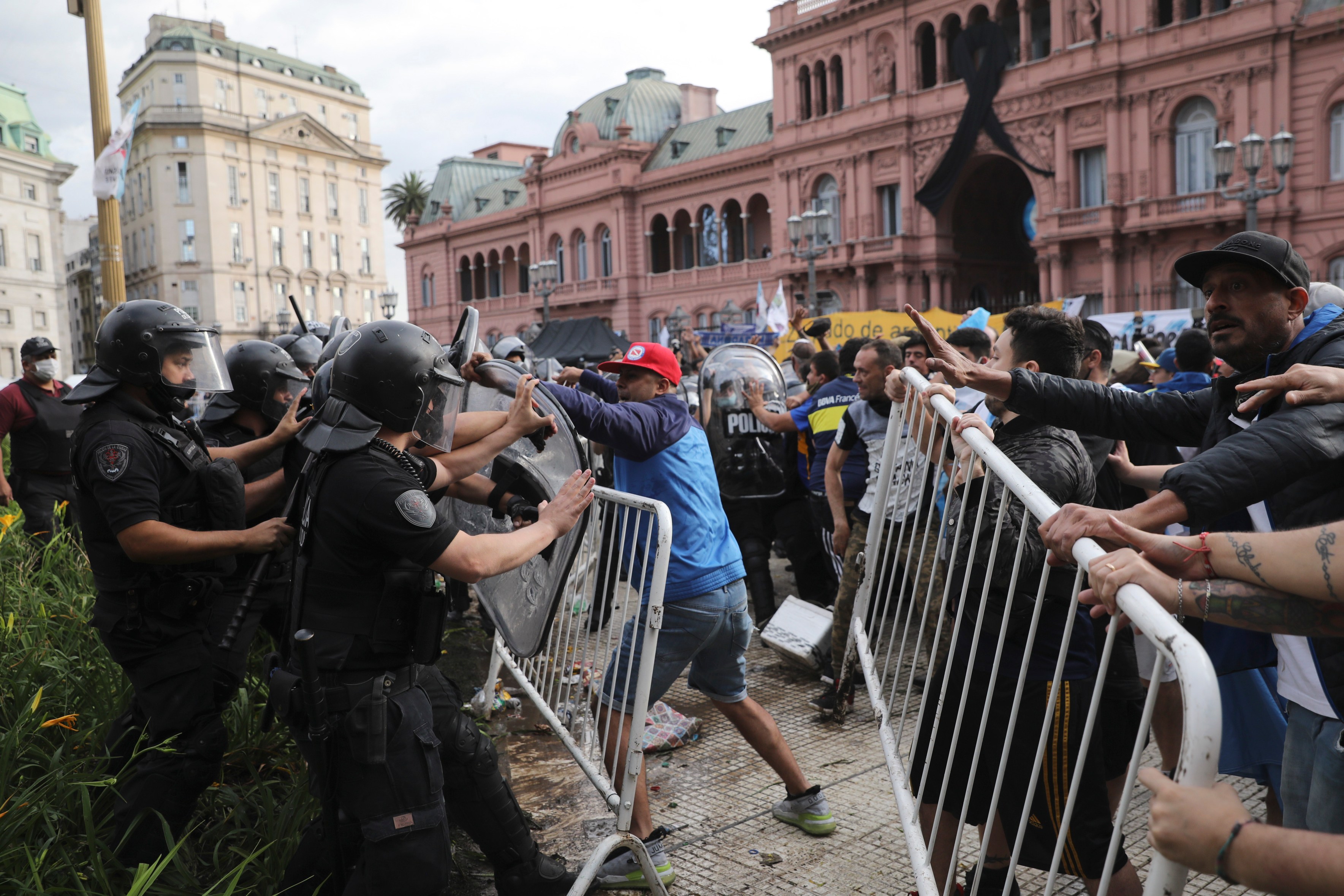 Soccer fans waiting to see Diego Maradona lying in state clash with police outside the presidential palace in Buenos Aires, Argentina, on Nov. 26, 2020. (Rodrigo Abd / Associated Press)