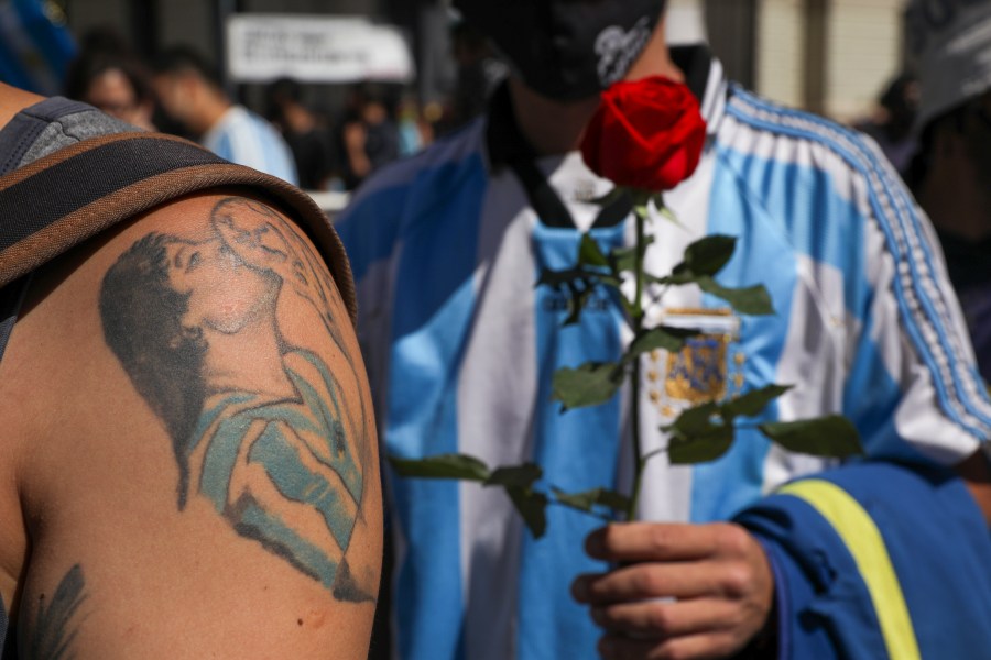 A mourner, sporting a tattoo of Diego Maradona on his forearm, waits in line to pay his final respects to the Argentine soccer great in Buenos Aires, Argentina, on Nov. 26, 2020. (Rodrigo Abd / Associated Press)