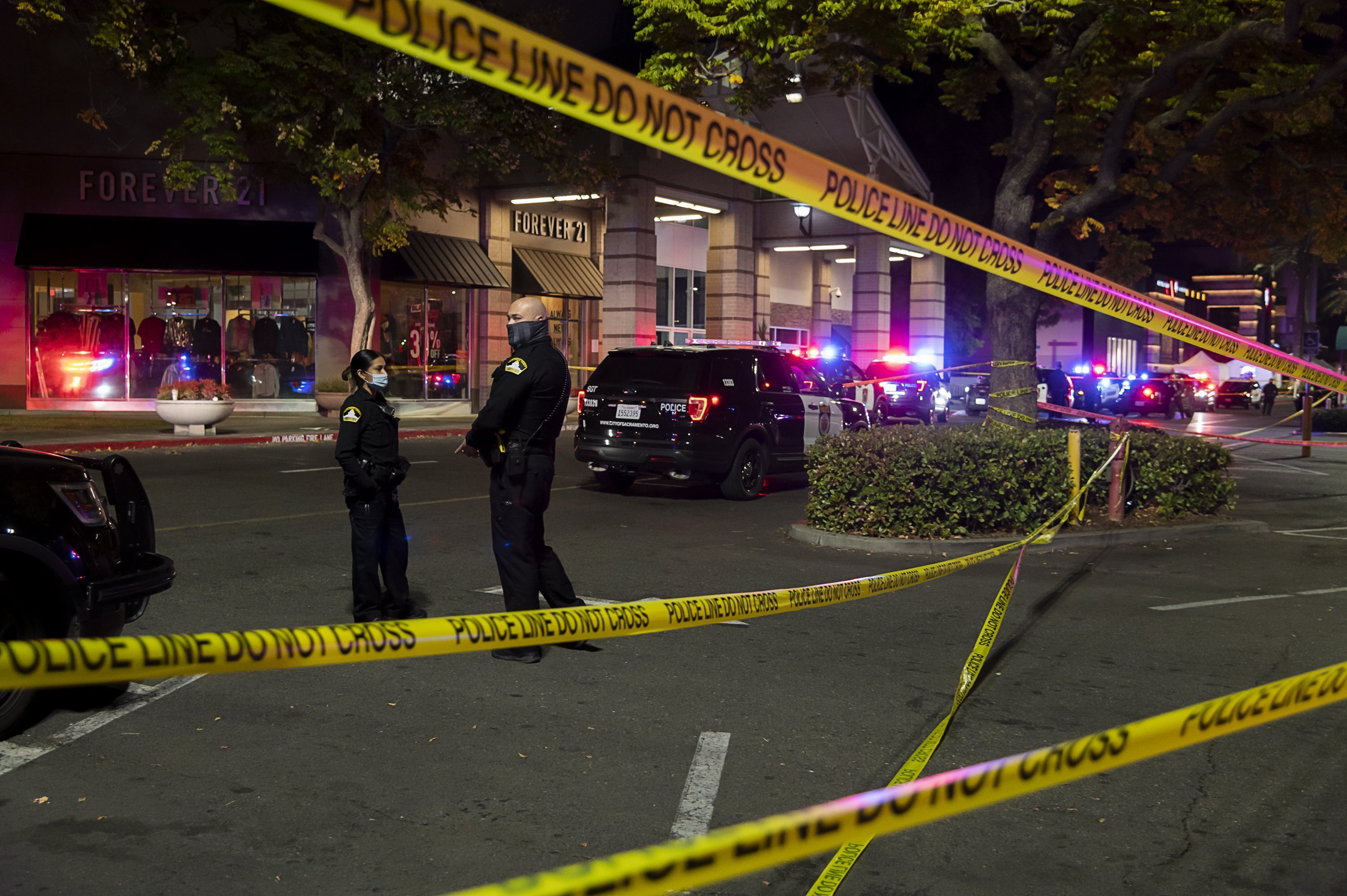 Police stand outside Arden Fair Mall in Sacramento after a shooting that left one person dead and another critically injured on Nov. 27, 2020. (Paul Kitagaki Jr. / The Sacramento Bee via Associated Press)