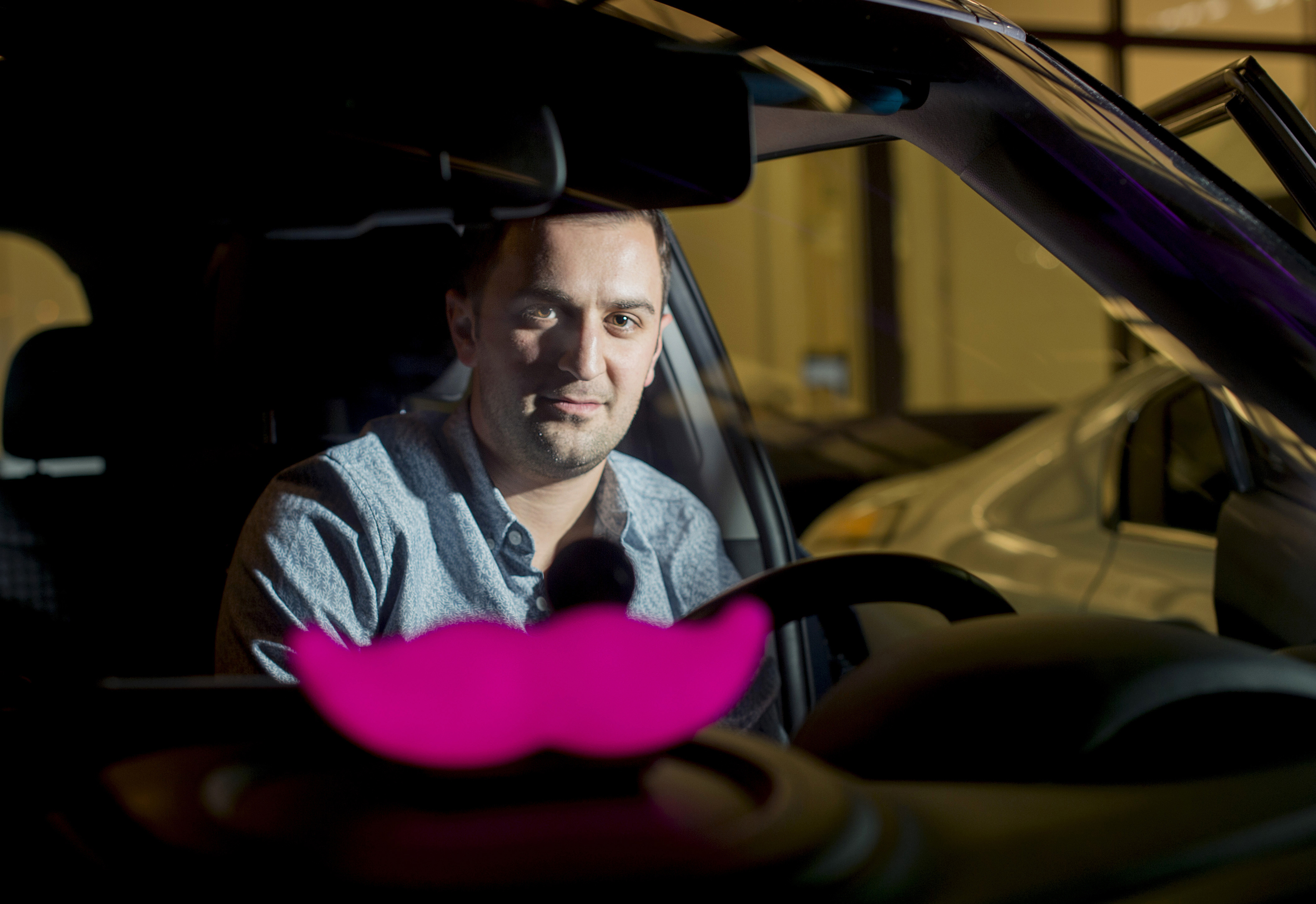 In this Jan. 26, 2015, file photo, Lyft co-founder John Zimmer displays his company's "glowstache" following a launch event in San Francisco. (Noah Berger/Associated Press)